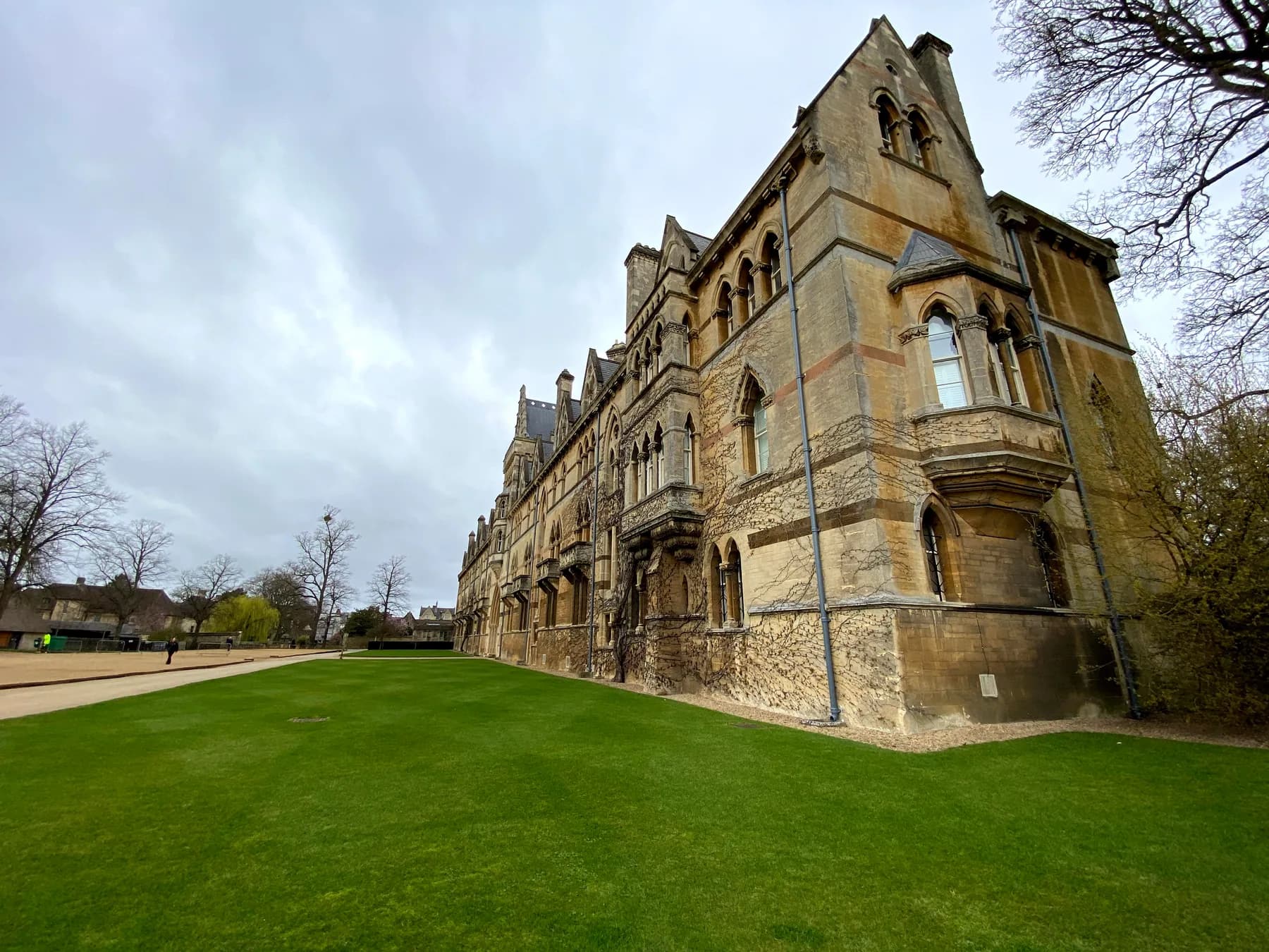 Oxford college stone buildings beside a green lawn