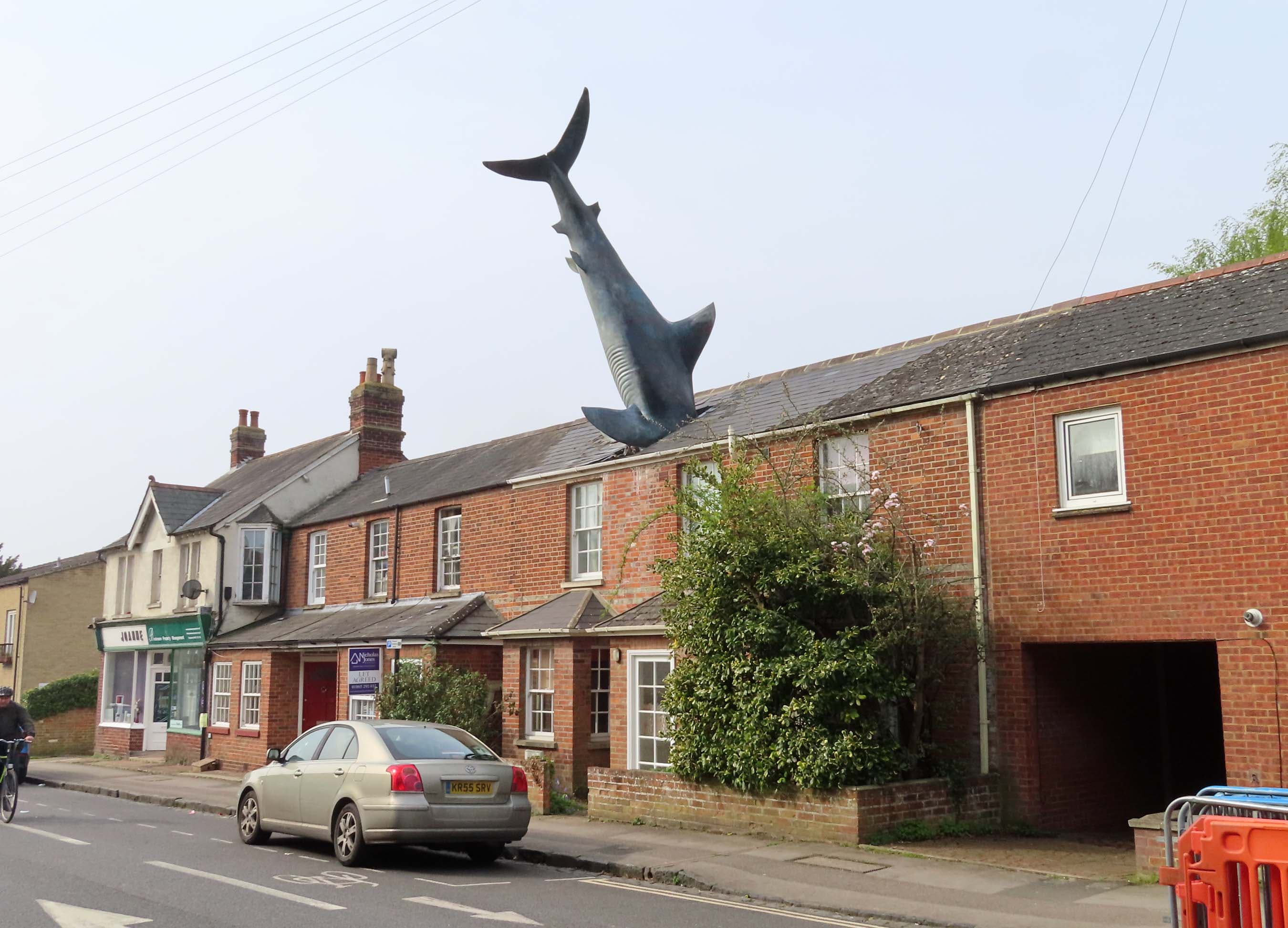 The Headington Shark rising from a brick house on New High Street