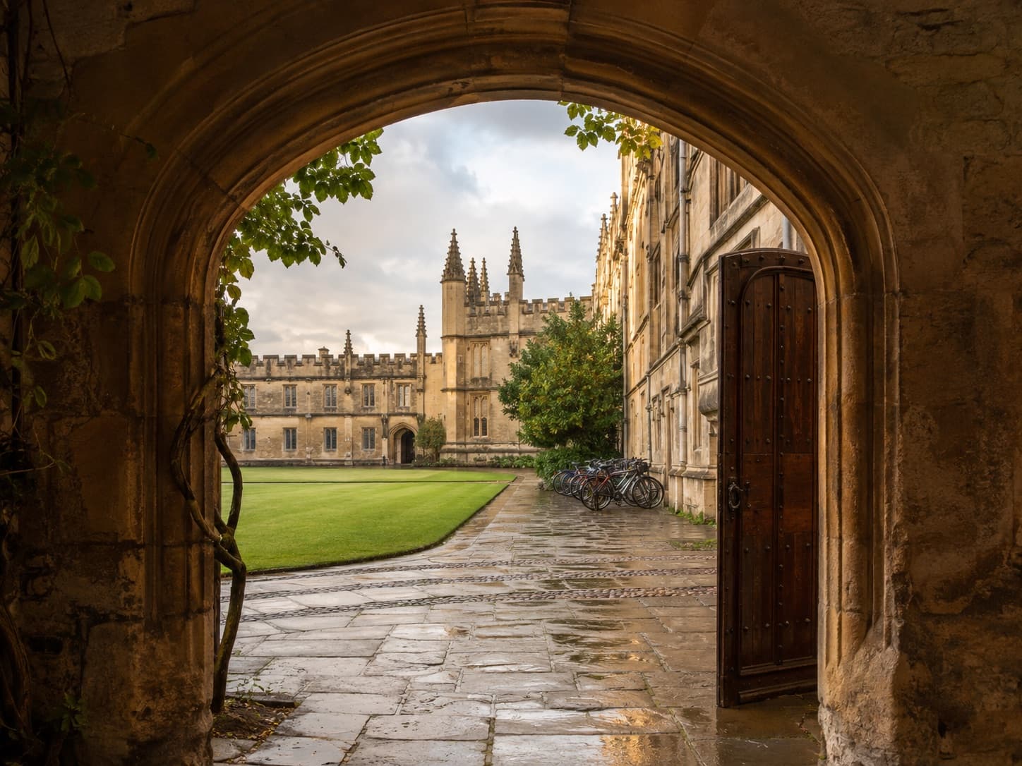 An Oxford college quadrangle seen through a stone arch